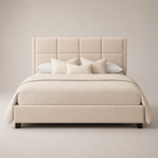 Luxury beige upholstered bed with tufted headboard, neutral bedding, and dark wood legs