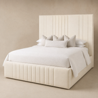Luxury cream upholstered bed with tufted headboard and base, styled with white bedding and pillows