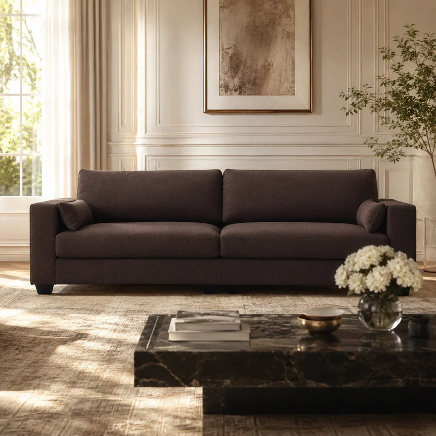 Luxury dark brown fabric sofa in elegant living room with marble coffee table and natural light