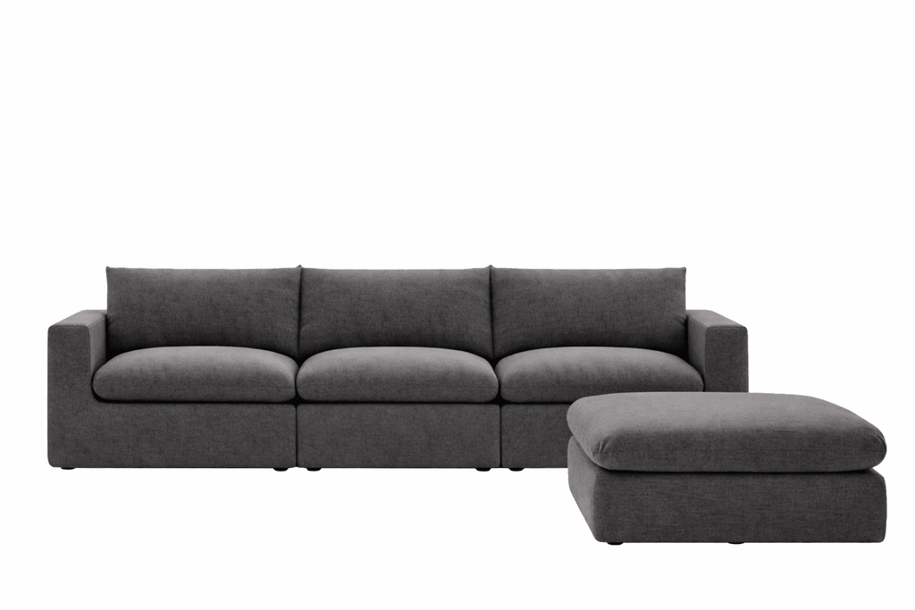 Modern dark grey sectional sofa with wide seat cushions and matching ottoman on white background