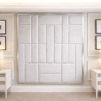 Modern bedroom with large upholstered panel headboard, white nightstands, and wall art