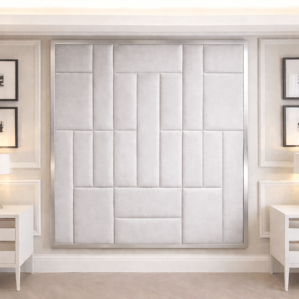 Modern bedroom with large upholstered panel headboard, white nightstands, and wall art