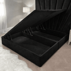 Black velvet ottoman storage bed with open lift-up base in a modern bedroom