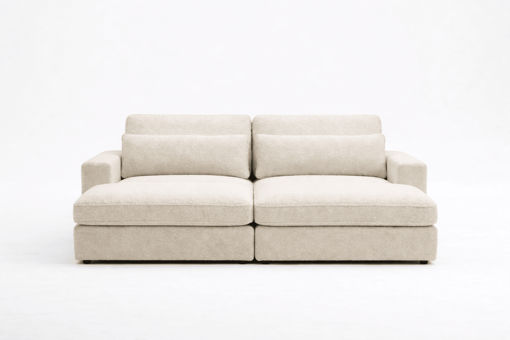 Modern beige fabric sofa with wide cushions and armrests on a white background