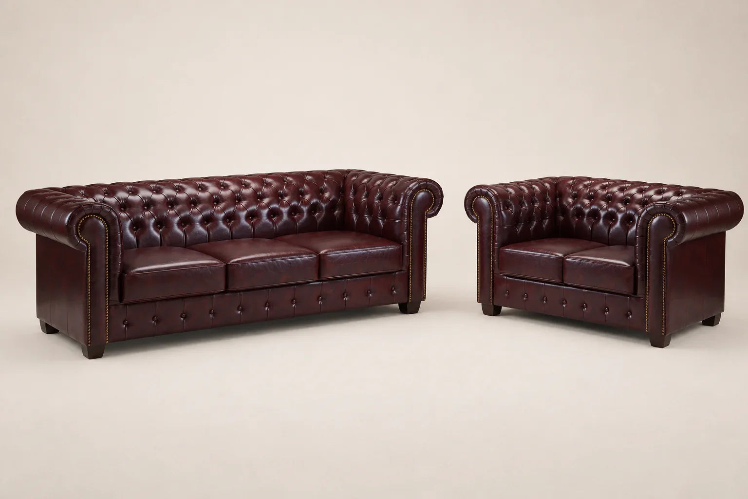 Luxury burgundy leather Chesterfield sofa and loveseat set with tufted upholstery and rolled arms