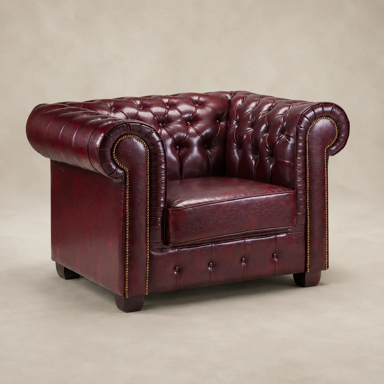 Luxury burgundy leather Chesterfield armchair with tufted back and rolled arms, ideal for living room comfort.