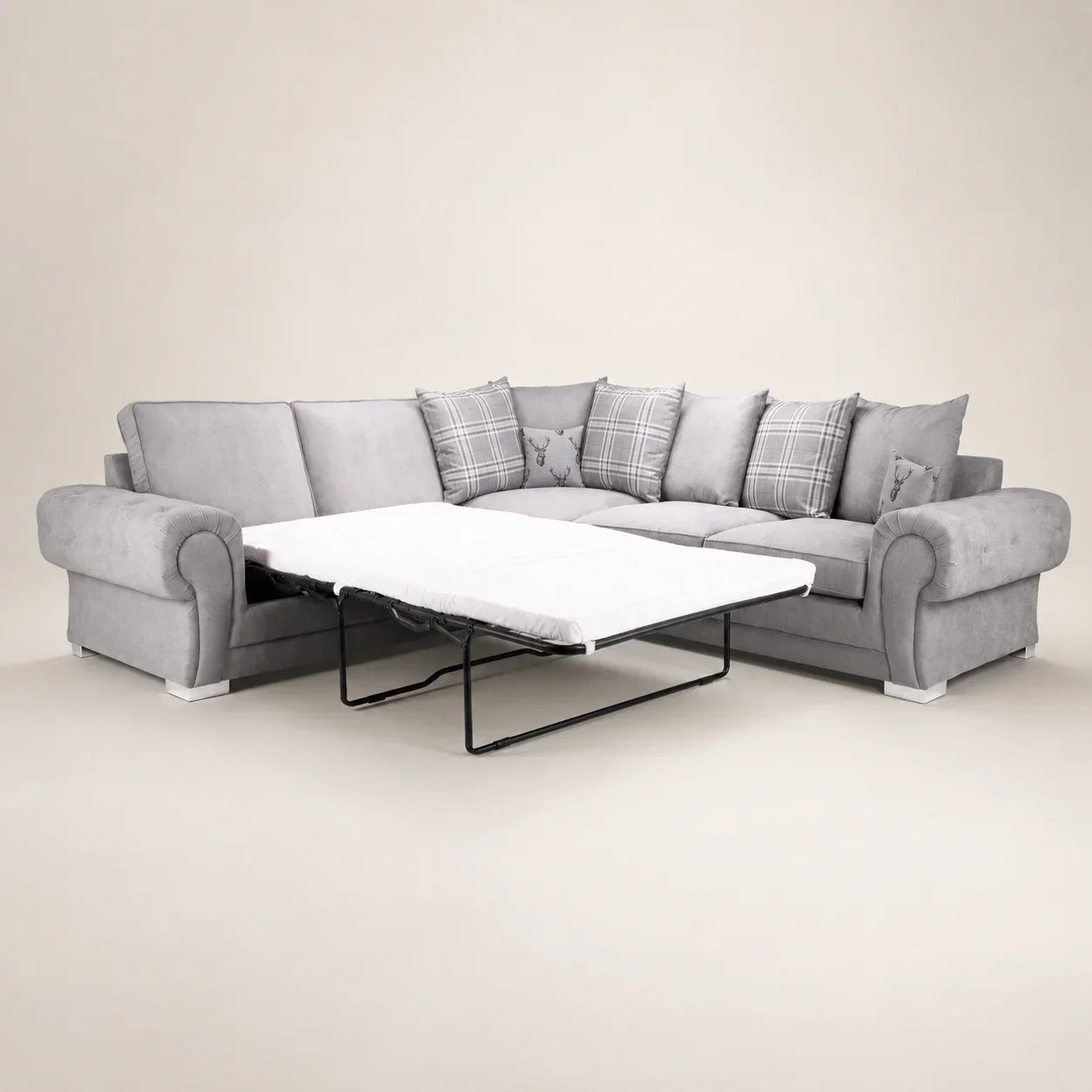 Grey L-shaped sofa bed with pull-out mattress, plaid and stag print cushions, luxury living room furniture