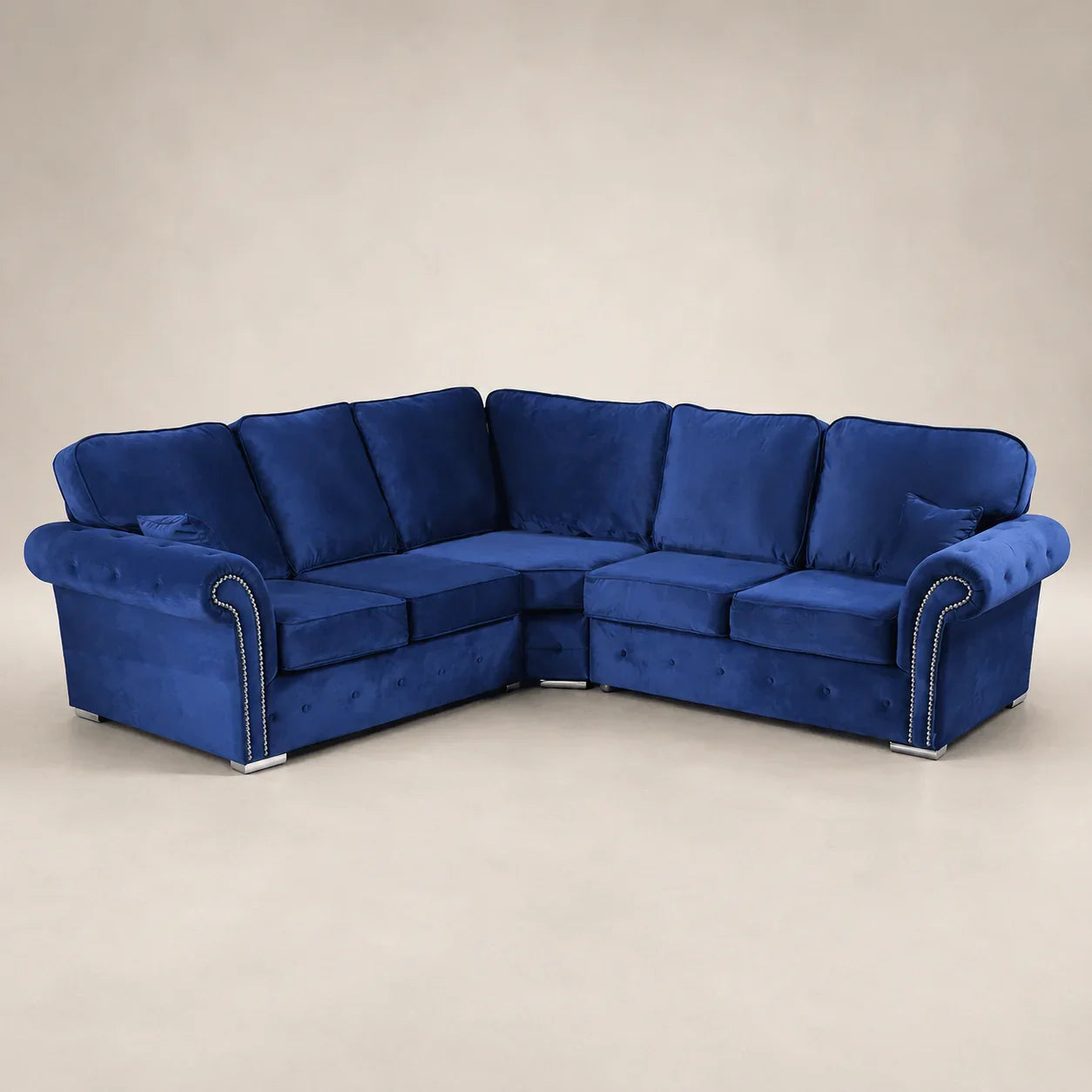 Luxury blue velvet corner sofa with tufted detailing and nailhead trim, perfect for modern living rooms.