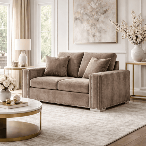 Modern beige velvet sofa with cushions in a bright living room, luxury decor, large windows