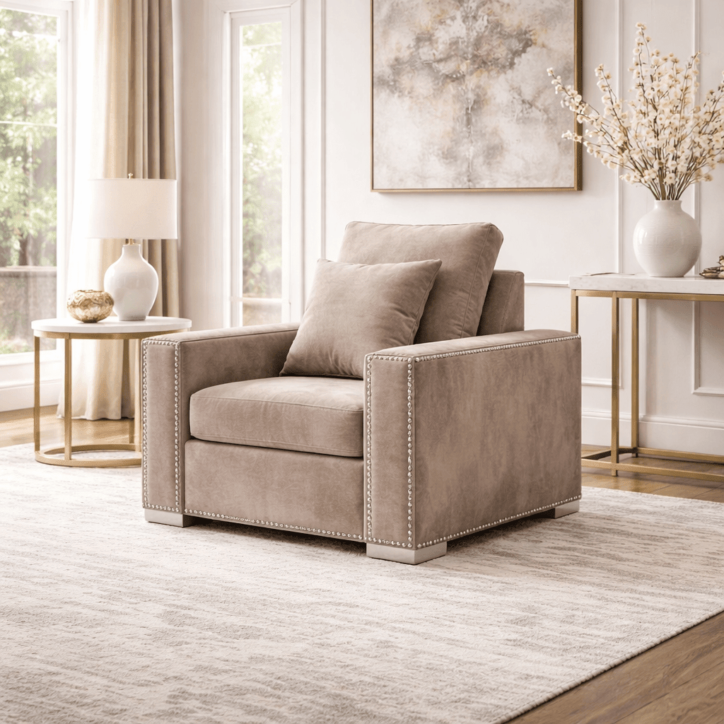 Beige velvet armchair with nailhead trim in a bright, modern living room
