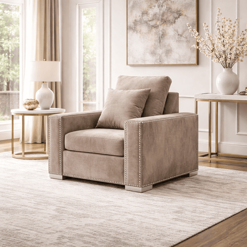 Beige velvet armchair with nailhead trim in a bright, modern living room
