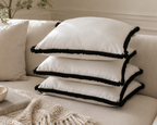 White velvet throw pillows with black fringe on a beige sofa, luxury home decor