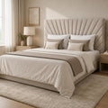 Luxury upholstered bed with tufted headboard, neutral bedding, and modern bedside table in bright bedroom