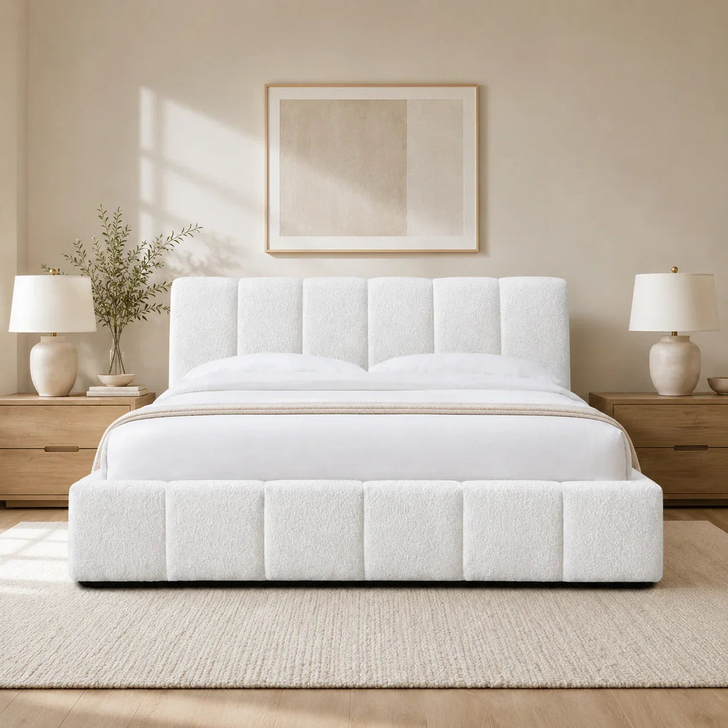 Luxury white upholstered bed with tufted headboard and base, styled in modern bedroom with wooden nightstands