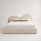 Luxury upholstered bed with curved headboard, white bedding, and beige textured fabric