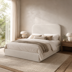 Luxury upholstered bed with neutral bedding, modern bedside tables, and natural light in a serene bedroom