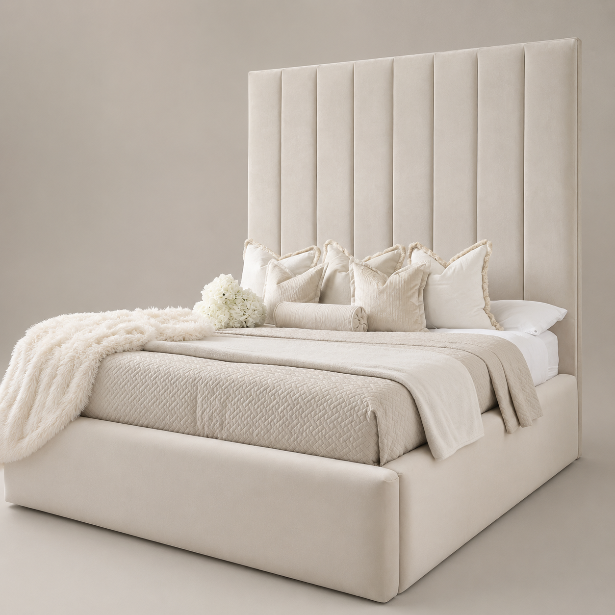 Luxury beige upholstered bed with tall tufted headboard, plush pillows, and cozy throws for modern bedroom decor