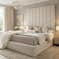 Luxury beige upholstered bed with tufted headboard, plush bedding, and crystal chandelier in modern bedroom