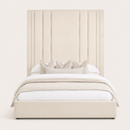 Luxury beige upholstered bed with tall panel headboard, white bedding, and decorative pillows