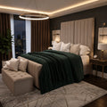 Luxury bedroom with tufted bed, green throw, and city view at night