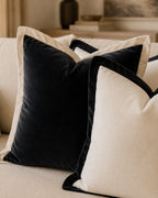 Luxury black and cream velvet throw pillows on a beige sofa, perfect for modern living room decor.