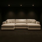 Modern beige sectional sofa with chaise lounge in a dark, minimalist living room