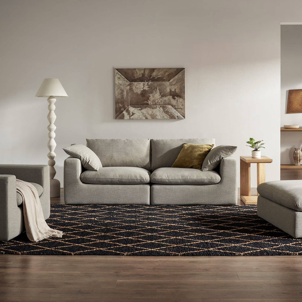 Modern living room with grey 3-seater sofa, armchair, ottoman and geometric rug