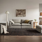 Modern living room with grey 3-seater sofa, armchair, ottoman and geometric rug