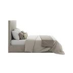 Modern upholstered bed with high headboard, neutral bedding, and decorative pillows
