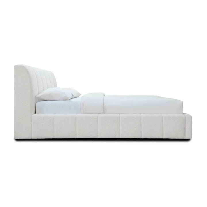 Modern upholstered white bed with vertical panel headboard and white bedding