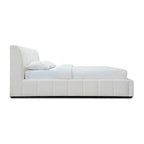 Modern upholstered white bed with vertical panel headboard and white bedding