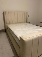 Modern beige upholstered bed with vertical panel headboard in a minimalist bedroom