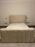 Beige upholstered bed with vertical panel headboard and footboard in a modern bedroom