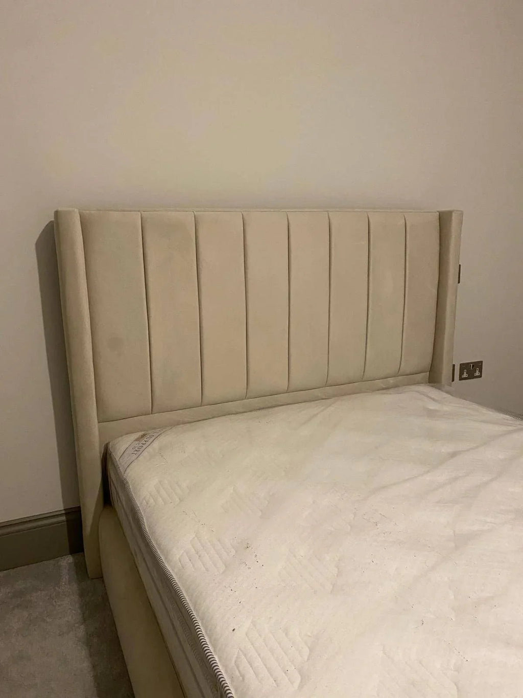 Cream upholstered bed frame with vertical panel headboard in modern bedroom