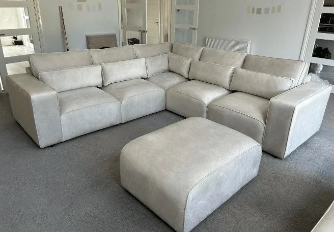 Modern light grey sectional sofa with matching ottoman in contemporary living room