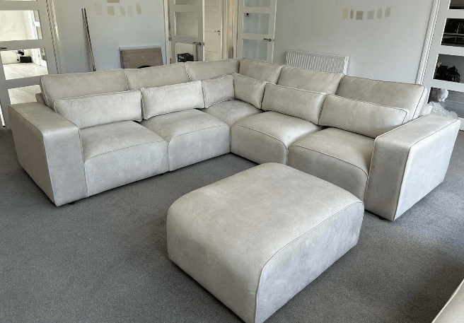 Modern light grey sectional sofa with matching ottoman in contemporary living room