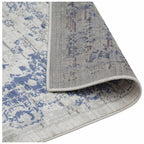 Blue and white distressed pattern area rug with textured weave and stitched edge