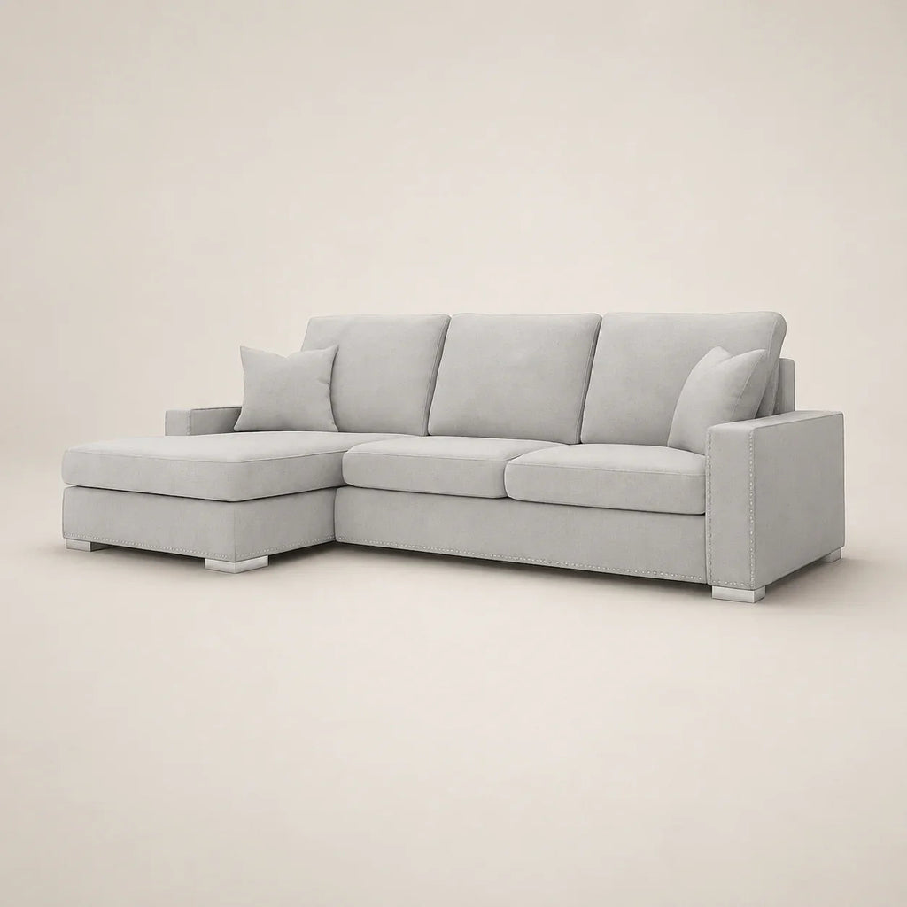 Light gray sectional sofa with chaise lounge and nailhead trim, luxury living room furniture