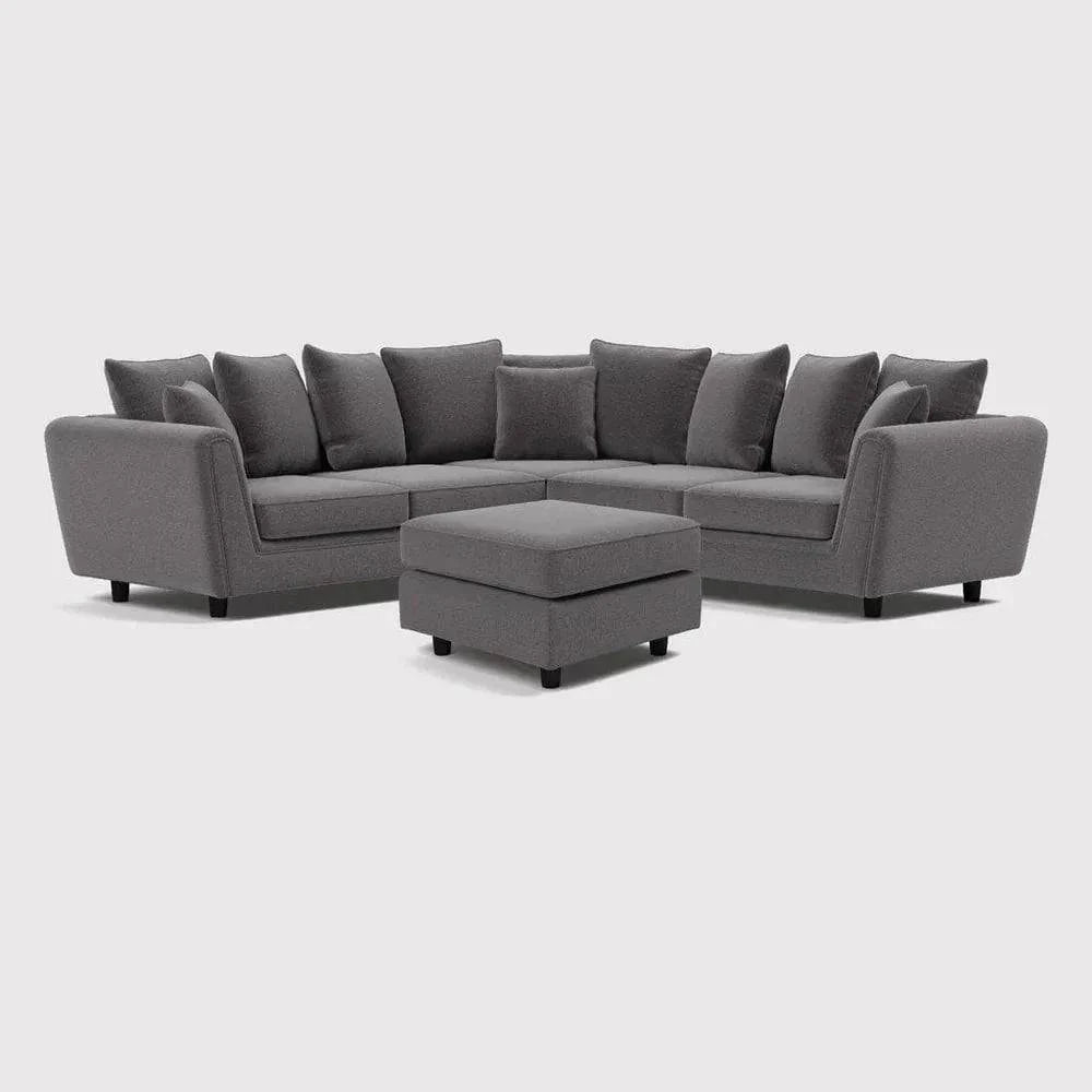 Grey double corner sofa with footstool and scatter cushions on white background