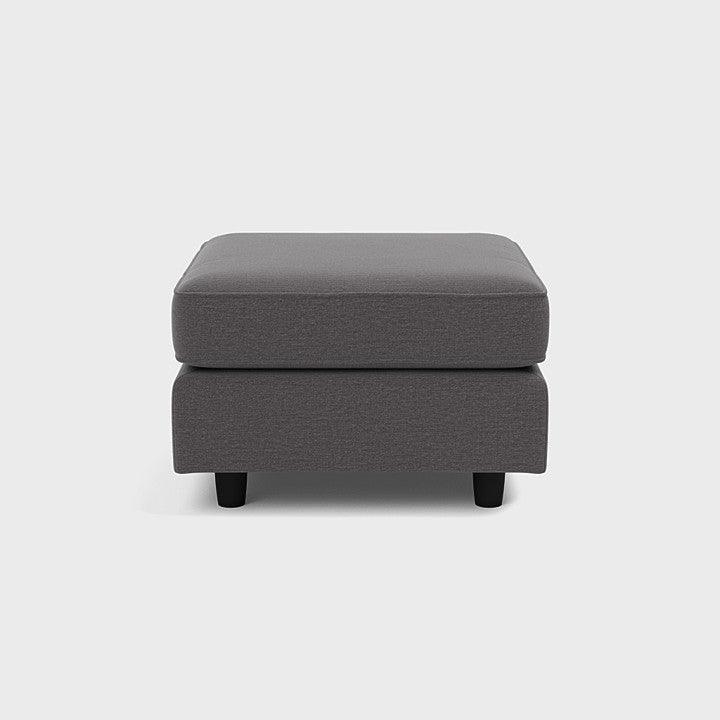 Modern grey fabric footstool with black legs on white background