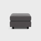 Modern grey fabric footstool with black legs on white background