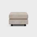 Beige upholstered footstool with black legs, minimalist design on white background