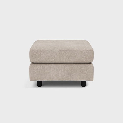 Beige upholstered footstool with black legs, minimalist design on white background