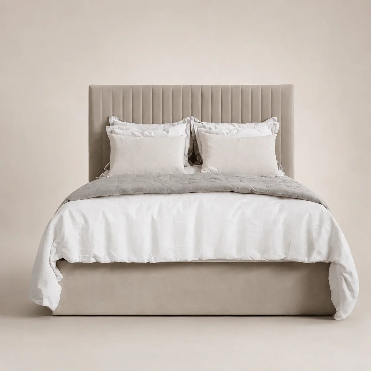 Luxury beige upholstered bed with tufted headboard, white linens, and neutral bedding for modern bedrooms