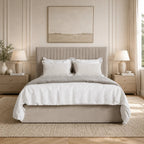 Luxury beige upholstered bed with white linens in a serene bedroom, perfect for modern UK homes.