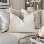 Luxury sofa with cream and silver velvet throw pillows, modern living room decor
