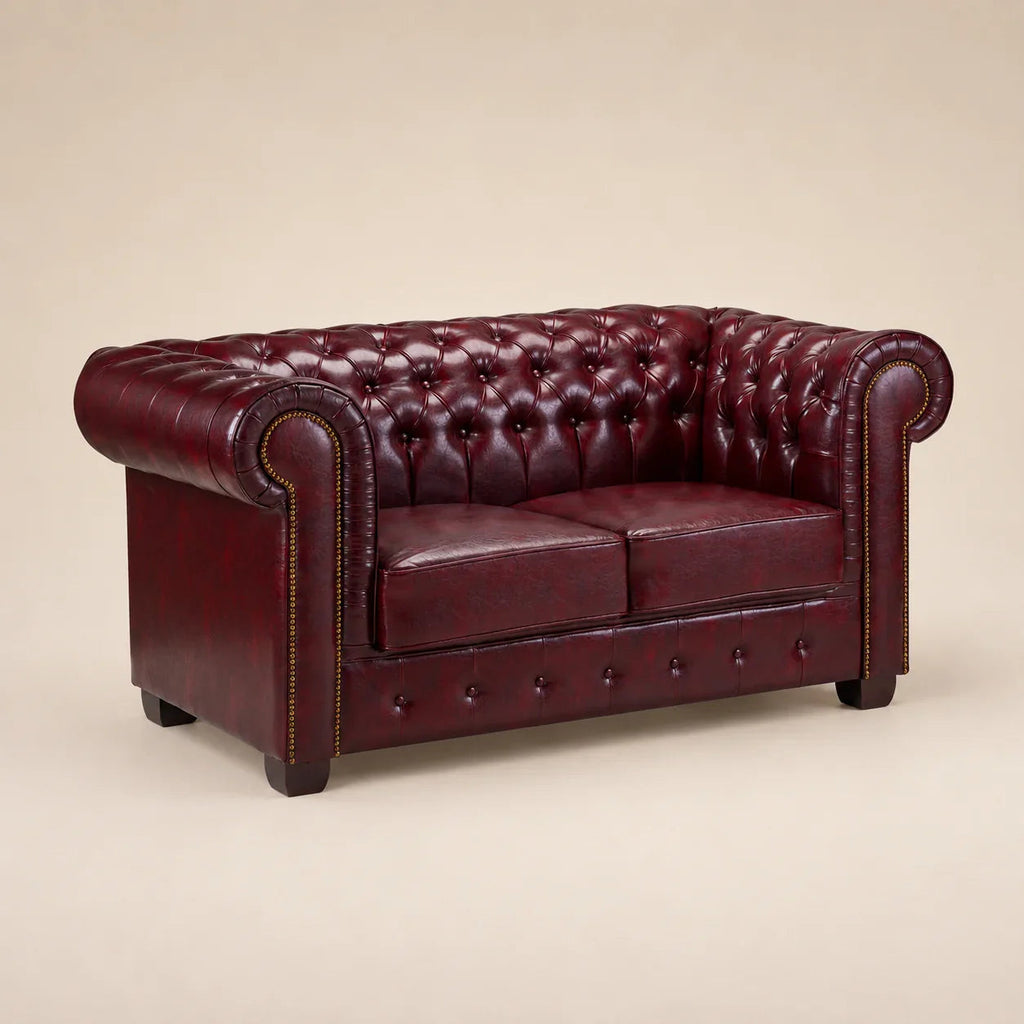 Luxury burgundy leather Chesterfield sofa with tufted back and rolled arms, ideal for elegant living rooms.