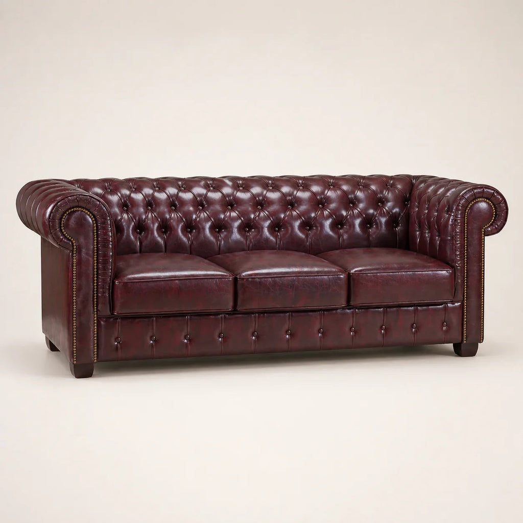 Luxury burgundy leather Chesterfield sofa with tufted back and rolled arms, ideal for elegant living rooms.