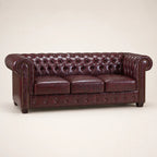 Luxury burgundy leather Chesterfield sofa with tufted back and rolled arms, ideal for elegant living rooms.