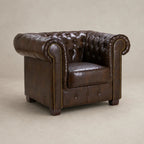 Luxury brown leather Chesterfield armchair with tufted back and rolled arms, ideal for living room comfort.